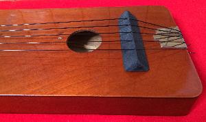 Sound hole and wooden bridge. Remaining screw holes. 5 on top and 7 on the back.